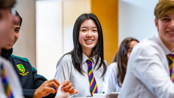 Schüler der Sandford Park School sitzen in einem Klassenzimmer zusammen an ihren Tischen.
