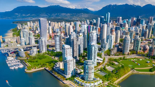 Blick auf die urbane Skyline mit Hochhäusern und Park vom Gelände der Sands Secondary School am Hafen vor Bergen.