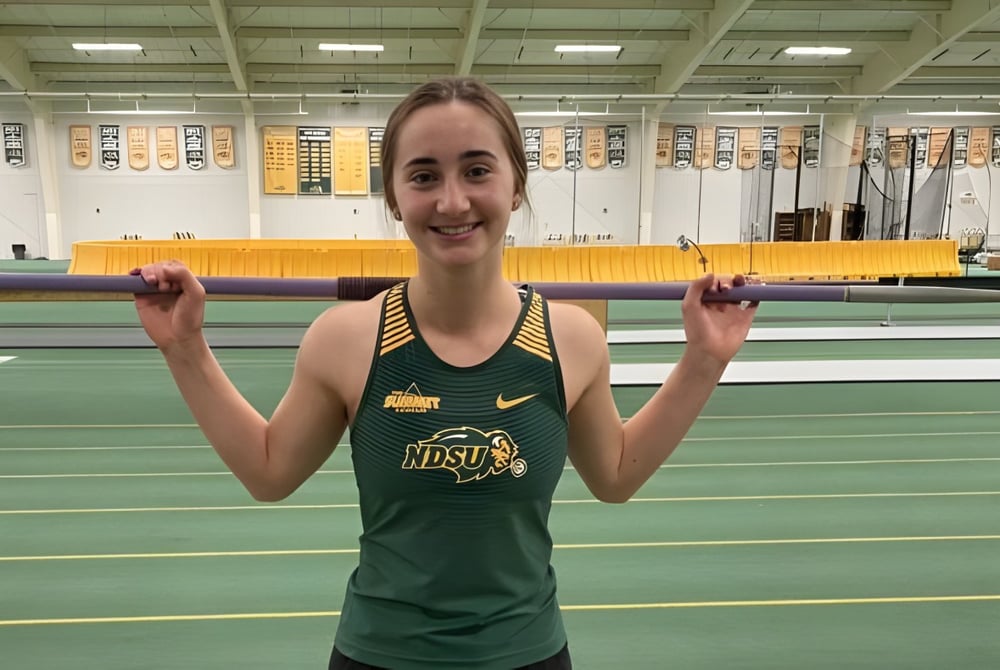 Eine Schülerin der Sandwich Secondary School steht in einer Sporthalle in einem grünen und gelben Trikot.
