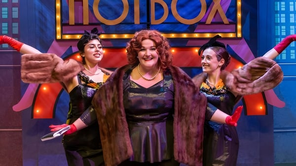 Drei Frauen mit bunten Haaren posieren vor dem beleuchteten Theater auf dem Campus des Santa Barbara City College.