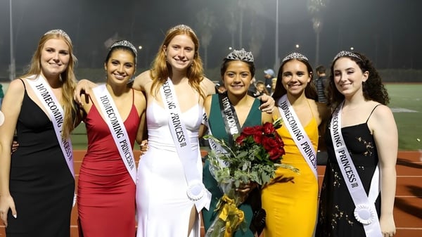 Eine Gruppe junger Frauen in festlicher Kleidung posiert gemeinsam auf einer Bühne auf dem Gelände der Santa Barbara High School.