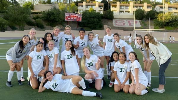 Eine Gruppe weiblicher Fußballspielerinnen der Santa Barbara High School posiert gemeinsam auf dem Fußballfeld.