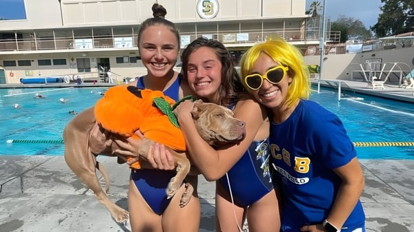 Drei Frauen posieren lächelnd vor einem Schwimmbecken auf dem Gelände des Santa Barbara Unified School District.