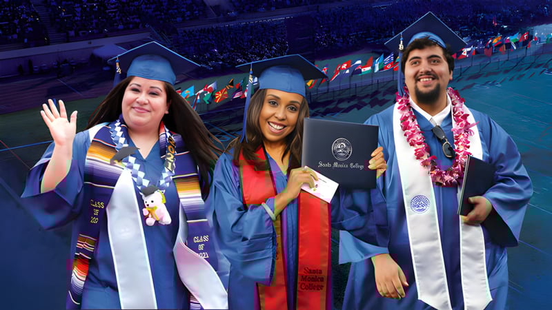 Drei Absolventinnen und Absolventen in blauen Abschlussroben posieren vor einer Menschenmenge auf dem Campus des Santa Monica College.