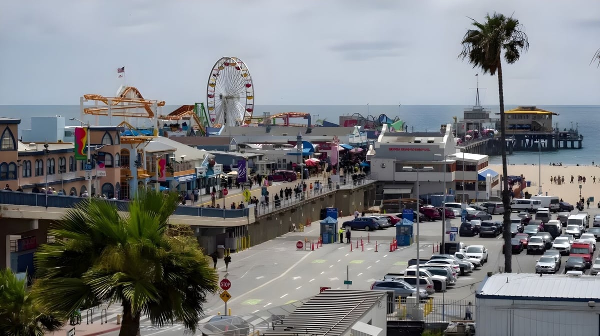 Der belebte Pier mit Riesenrad und Palmen in der Nähe des Santa Monica College in einer urbanen Umgebung.