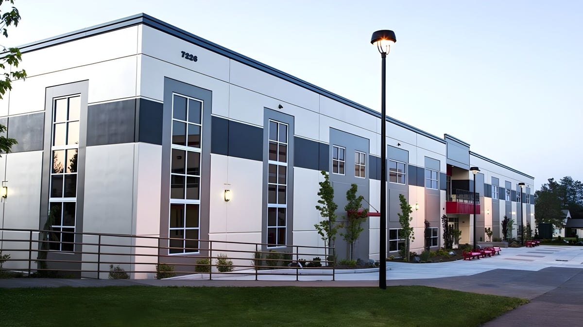 Modernes mehrstöckiges Gebäude der Santiam Christian School mit Glas- und Metallfassade umgeben von gepflegtem Rasen und Beleuchtung.