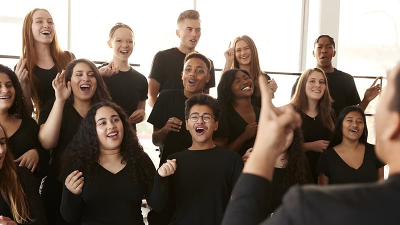 Eine Gruppe Schüler der Santiam Christian School zeigt sich vor einem hellen Naturhintergrund ausdrucksstark und hebt die Hände.