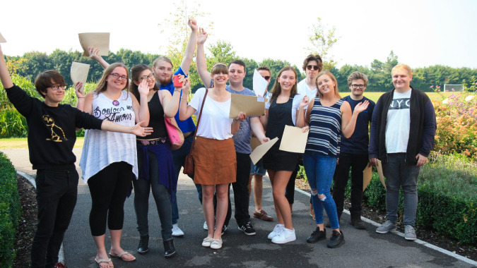 Eine Gruppe Schülerinnen der Sarum Academy steht draußen in einem parkähnlichen Bereich mit Bäumen im Hintergrund.