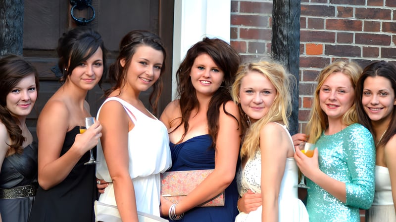 Sechs Schülerinnen stehen vor einem Backsteingebäude auf dem Campus der Sarum Academy.