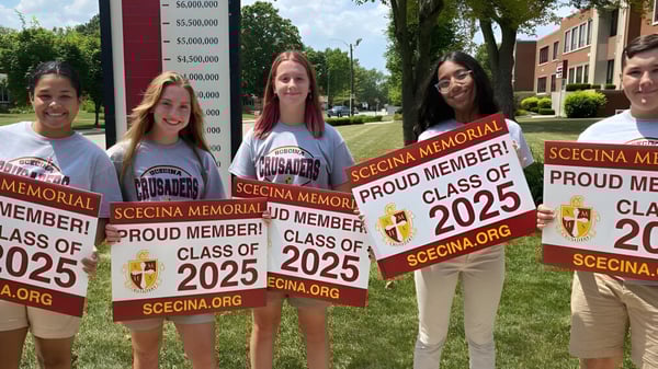 Schüler der Scecina Memorial High School zeigen im Freien stolz ihre Schilder der Class of 2025.
