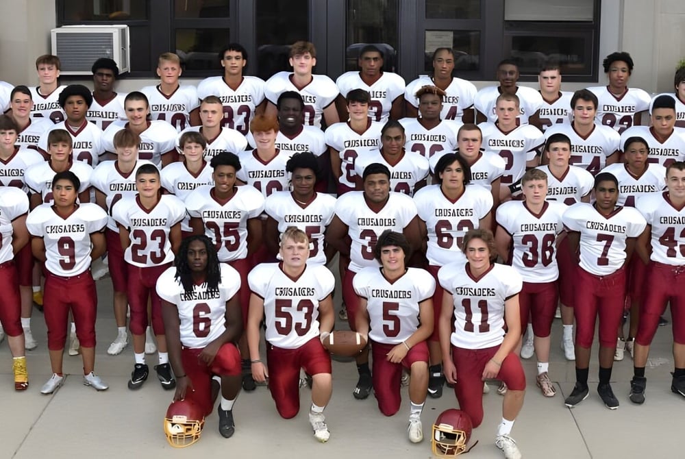 Eine große Gruppe von sportlichen Schülerinnen und Schülern der Scecina Memorial High School steht in einheitlichen Trikots vor einem Gebäude.