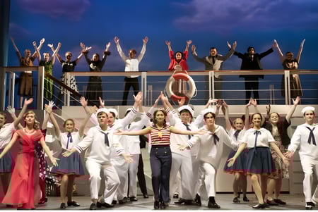 Eine Gruppe von Schülerinnen und Schülern des Schull Community College steht in verschiedenen Kostümen auf einer Bühne vor einem wolkigen Himmel.