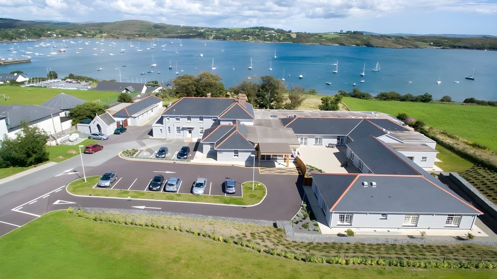 Blick auf den Hafen und die umliegenden Wohngebäude in der Küstenstadt beim Schull Community College.