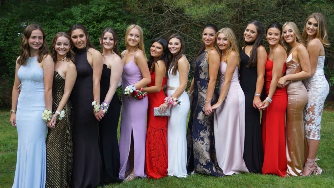 Eine Gruppe junger Frauen in eleganten Festkleidern im Freien auf dem Gelände der Scoil Mhuire Cork.