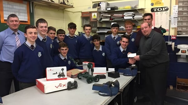 Schüler der Scoil Mhuire gan Smál arbeiten gemeinsam an einem Elektronikprojekt mit verschiedenen Geräten in einem Klassenraum.