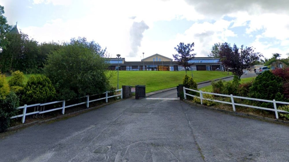 Ein gepflasterter Weg führt zu einer Wiese mit Bäumen auf dem Schulgelände von Scoil Mhuire Kanturk.