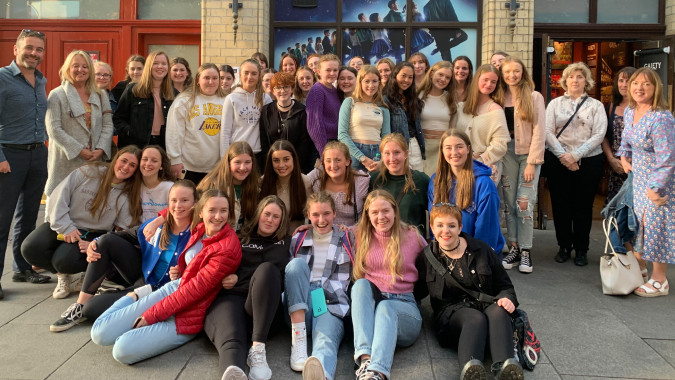 Eine Gruppe Schülerinnen steht vor einem bunten Wandbild auf dem Campus der Scoil Mhuire (Trim).