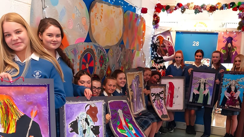 Eine Gruppe Schülerinnen und Schüler steht vor einem bunten Wandbild im Klassenraum der Scoil Mhuire (Trim).