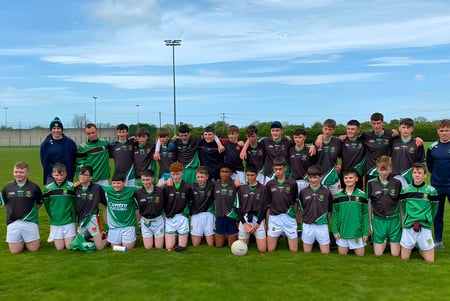 Schülerinnen und Schüler der Scoil Ruáin posieren gemeinsam als Fußballmannschaft auf einem Spielfeld.