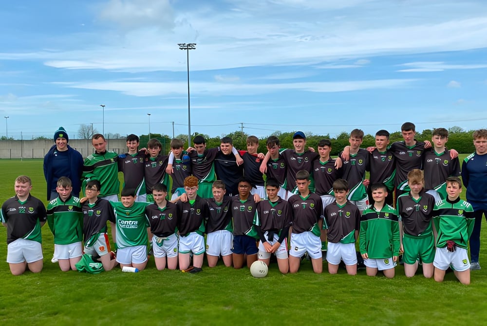 Schülerinnen und Schüler der Scoil Ruáin posieren gemeinsam als Fußballmannschaft auf einem Spielfeld.