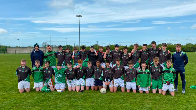 Eine Gruppe junger Fußballspielerinnen und Fußballspieler auf dem Sportplatz der Scoil Ruáin posiert gemeinsam.