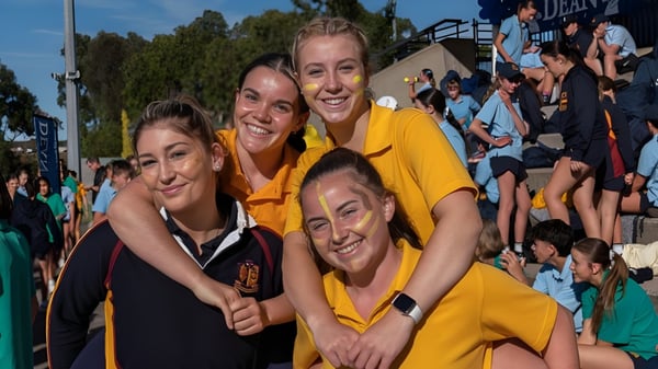 Eine Gruppe von Schülerinnen in gelben Shirts steht zusammen auf dem Campus des Scotch Oakburn College.