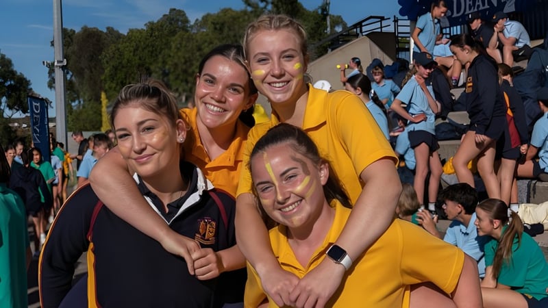 Eine Gruppe von Schülerinnen in gelben Shirts steht zusammen auf dem Campus des Scotch Oakburn College.