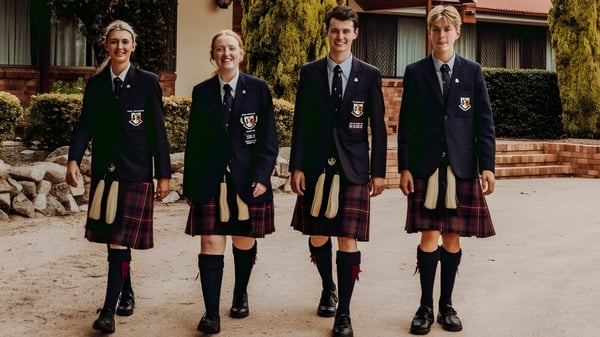 Vier Schüler in Schuluniformen stehen vor dem Backsteingebäude auf dem Campus des Scots PGC College.