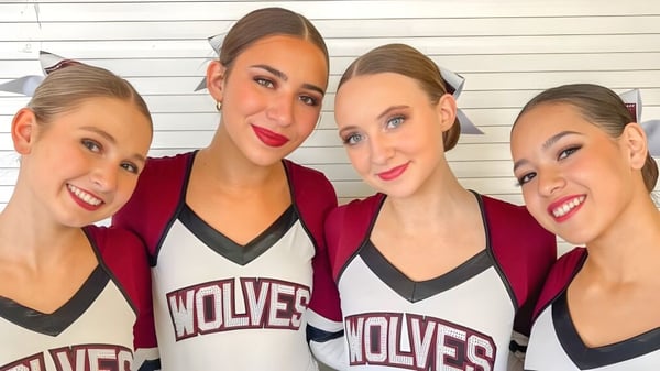 Vier junge Sportlerinnen posieren in roten und weißen Trikots mit der Aufschrift Wolves im Scottsdale Unified School District.