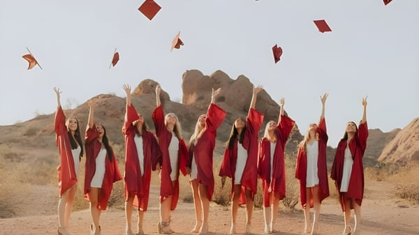 Eine Gruppe rot gekleideter Personen steht vor einer bergigen Landschaft auf dem Gelände des Scottsdale Unified School District.