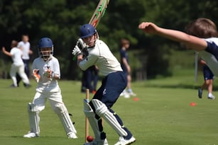 Ein Cricketspieler im weißen Trikot beim Schlagen des Balls auf dem Spielfeld des Seaford College.
