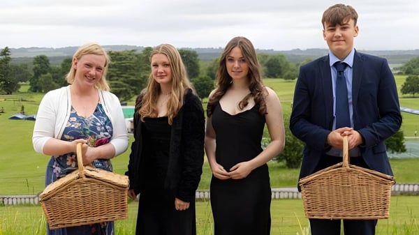 Vier Schülerinnen und Schüler vom Seaford College stehen gemeinsam auf einer Wiese mit Hügeln und Bäumen im Hintergrund.