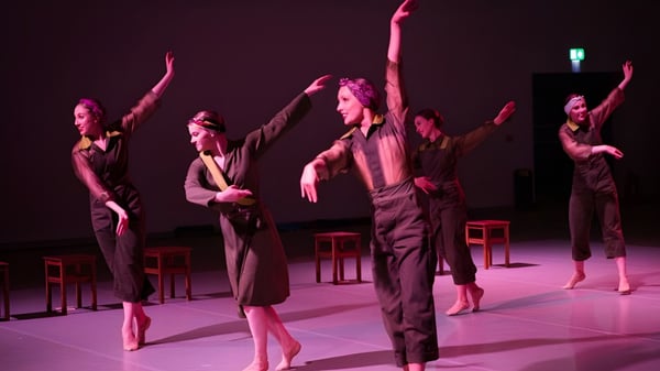 Eine Gruppe von Schülerinnen und Schülern des Seaford College tanzt synchron auf der Bühne in pink-violett beleuchtetem Raum.