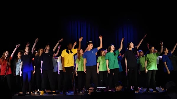 Eine Gruppe von Schülerinnen und Schülern der Seaford Head School steht auf der Bühne und hebt die Arme jubelnd.