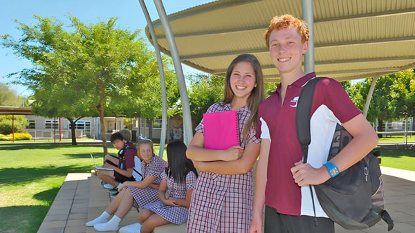 Eine Gruppe Schüler steht auf einer Wiese vor einem Gebäude auf dem Campus des Seaford Secondary College.