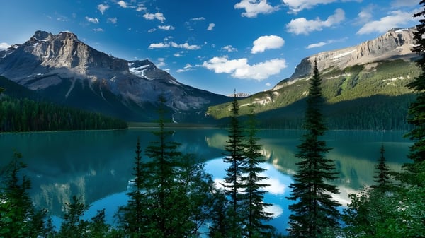 Ein ruhiger alpiner See mit schneebedeckten Bergen und Wald spiegelt sich im Wasser nahe der Seaquam Secondary School.