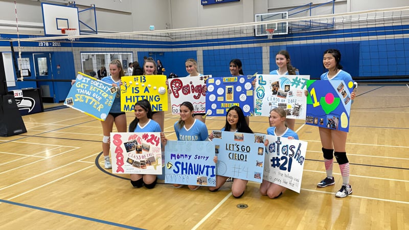 Eine Gruppe von Schülerinnen der Seaquam Secondary School hält bunte Banner auf dem Basketballplatz.