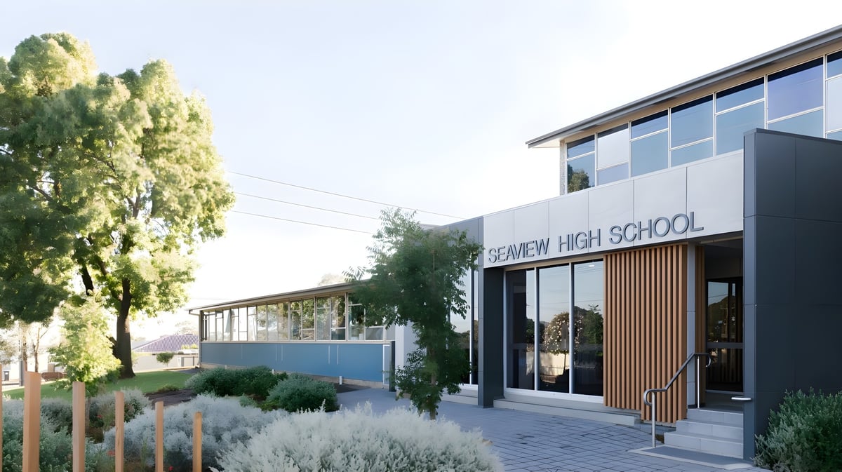 Das moderne Schulgebäude der Seaview High School ist von viel Grün umgeben und vor blauem Himmel zu sehen.