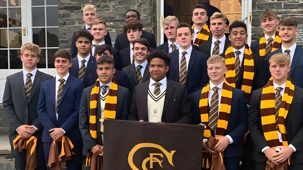 Eine Gruppe Schüler der Sedbergh School steht vor einem steinernen Schulgebäude in Schuluniformen mit Anzügen und gestreiften Schals.