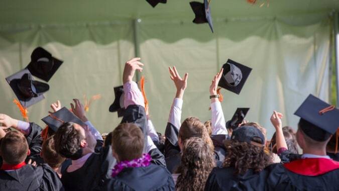 Eine Gruppe von Absolventinnen und Absolventen feiert ihre Abschlussfeier auf dem Campus der SEK International School El Castillo.