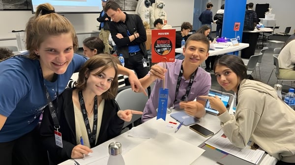 Eine Gruppe Schülerinnen und Schüler der SEK International School Catalunya steht gemeinsam bei einer Veranstaltung um einen Tisch.