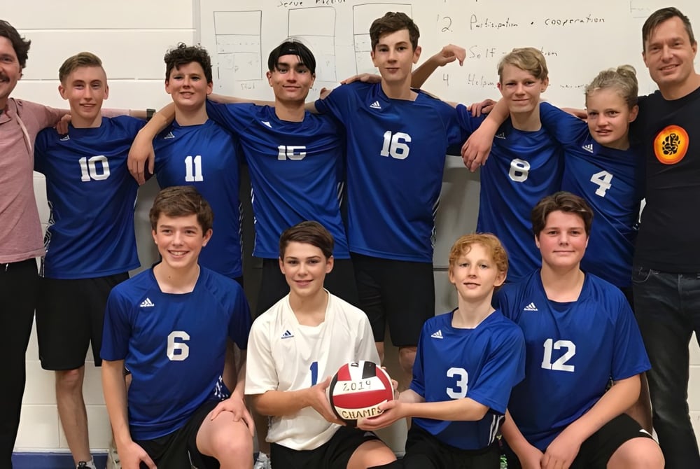 Eine Gruppe von Schülerinnen und Schülern der Selkirk Secondary School posiert als Volleyballteam in der Sporthalle.