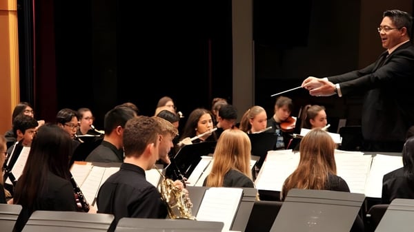 Ein Dirigent leitet ein Orchester bei einer Aufführung auf dem Campus der Semiahmoo Secondary School.