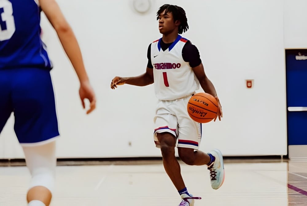 Ein Basketballspieler in weißem Trikot dribbelt den Ball auf dem Spielfeld der Semiahmoo Secondary School.
