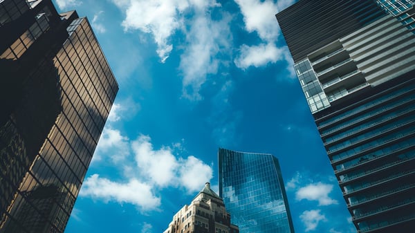 Hochhäuser mit Glasfassaden vor blauem Himmel mit Wolken in der Nähe der Sentinel Secondary School.