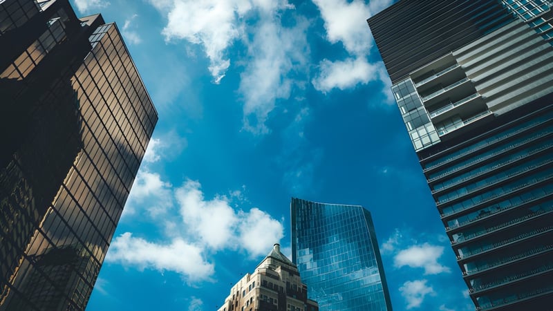 Hochhäuser mit Glasfassaden vor blauem Himmel mit Wolken in der Nähe der Sentinel Secondary School.