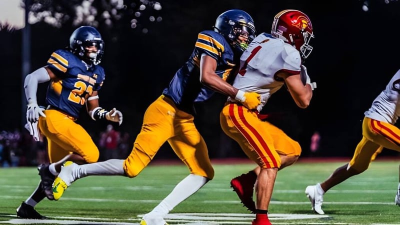 Zwei Footballspieler auf dem Feld bei Shady Side Academy während eines Spiels in der Dämmerung.
