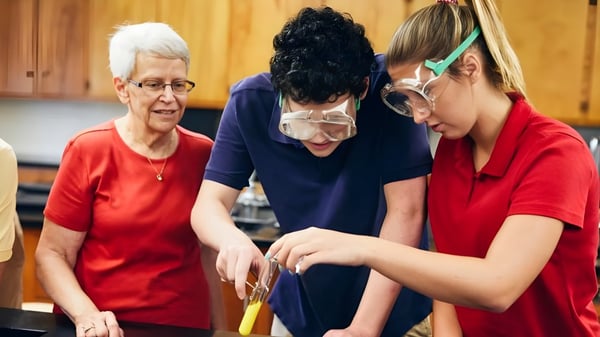 Drei Schülerinnen und Schüler der Shalom Christian Academy arbeiten gemeinsam in einer Küche mit Holzverkleidung.