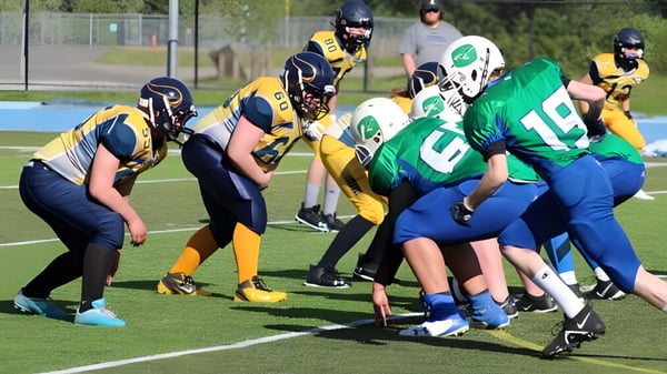 Eine Gruppe von Footballspielern bestreitet ein Spiel auf dem Sportplatz der Shas Ti Kelly Road Secondary School.