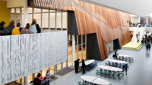 Moderner Innenraum mit Holzwand und Sitzreihen auf dem Campus der Shas Ti Kelly Road Secondary School.